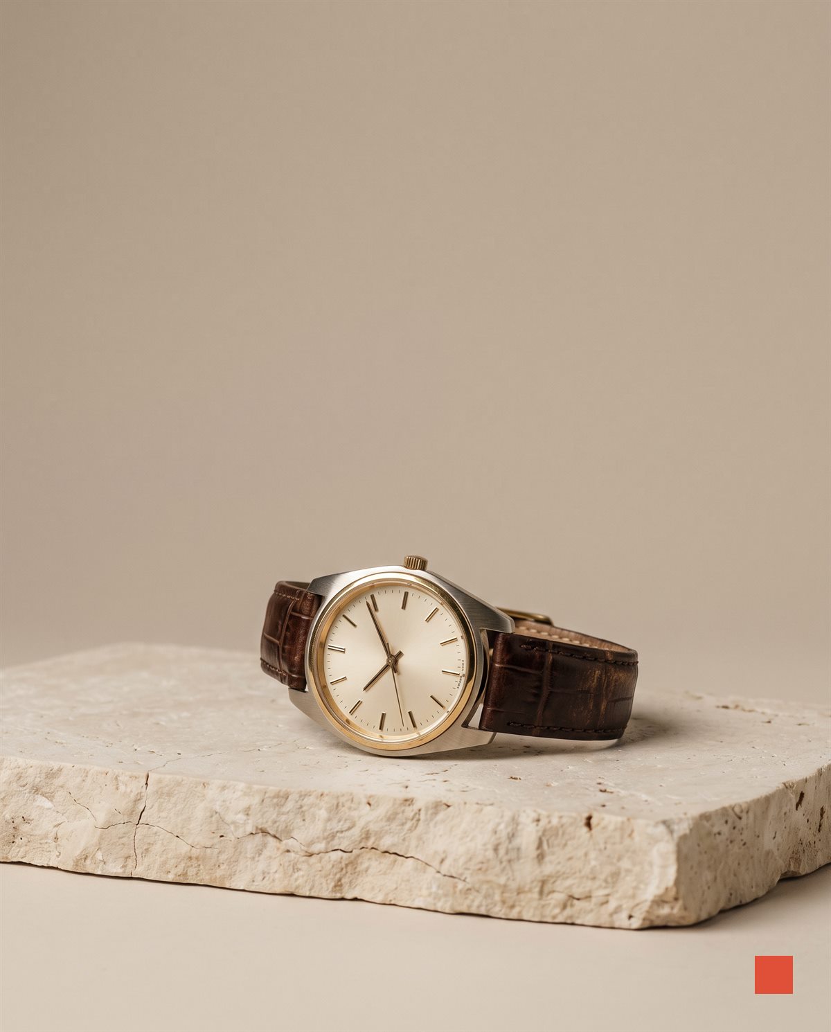 Dress watch with a cream dial and brown leather strap on limestone